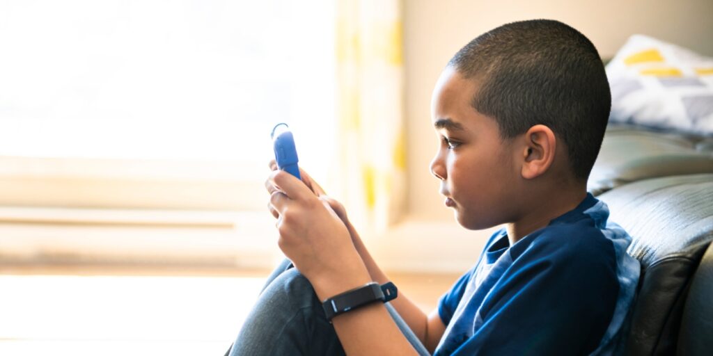 young boy reading on tablet