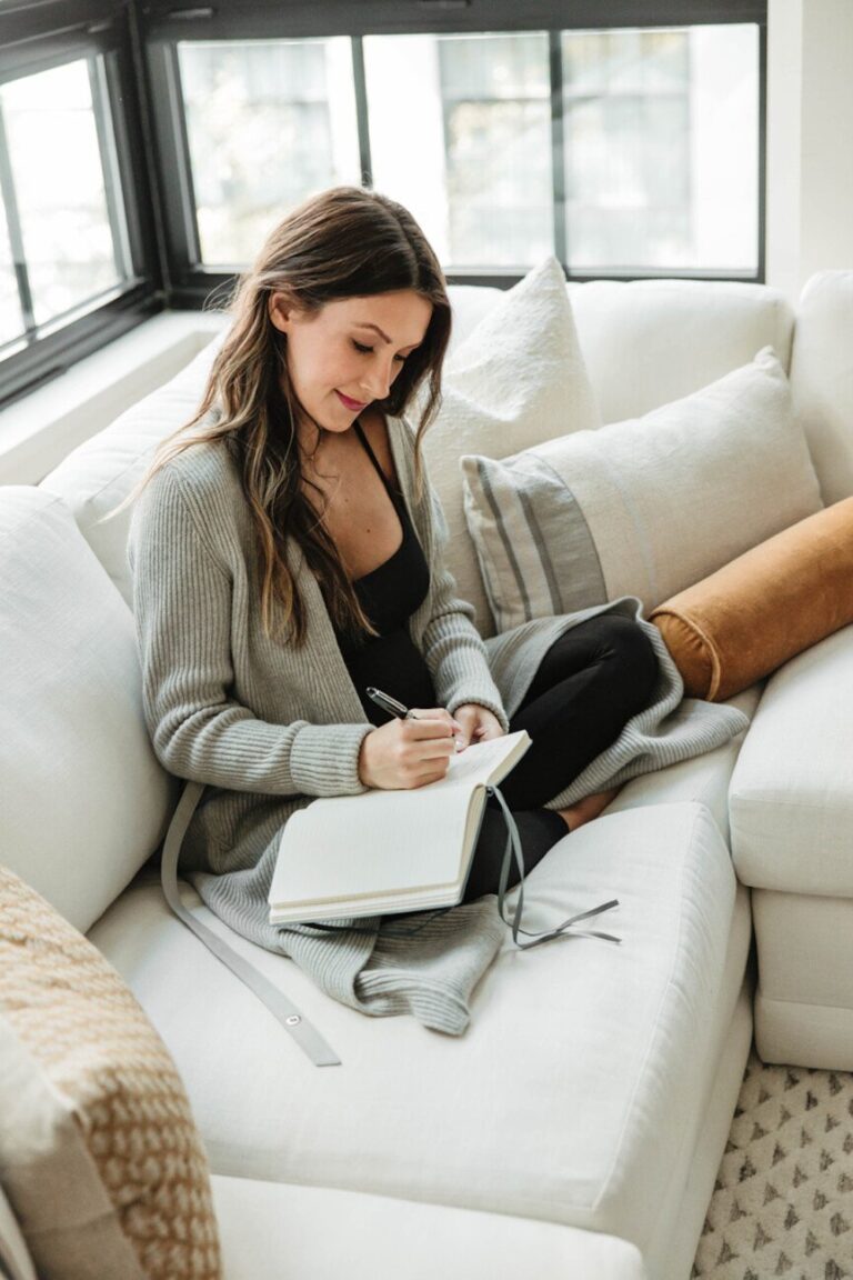 woman journaling on couch 865x1298