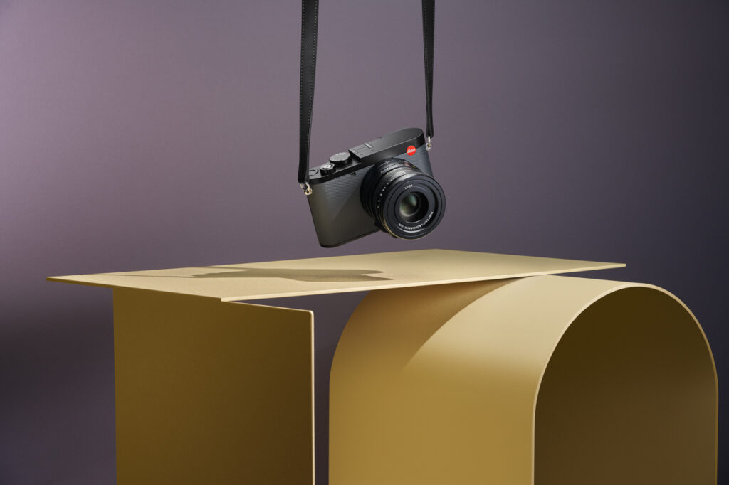 leica q3 43 hanging over yellow furniture