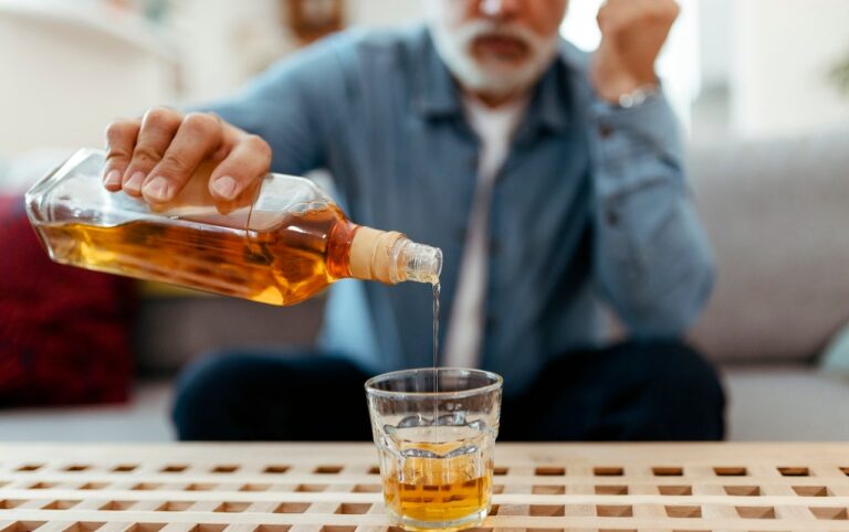 older man pouring whiskey